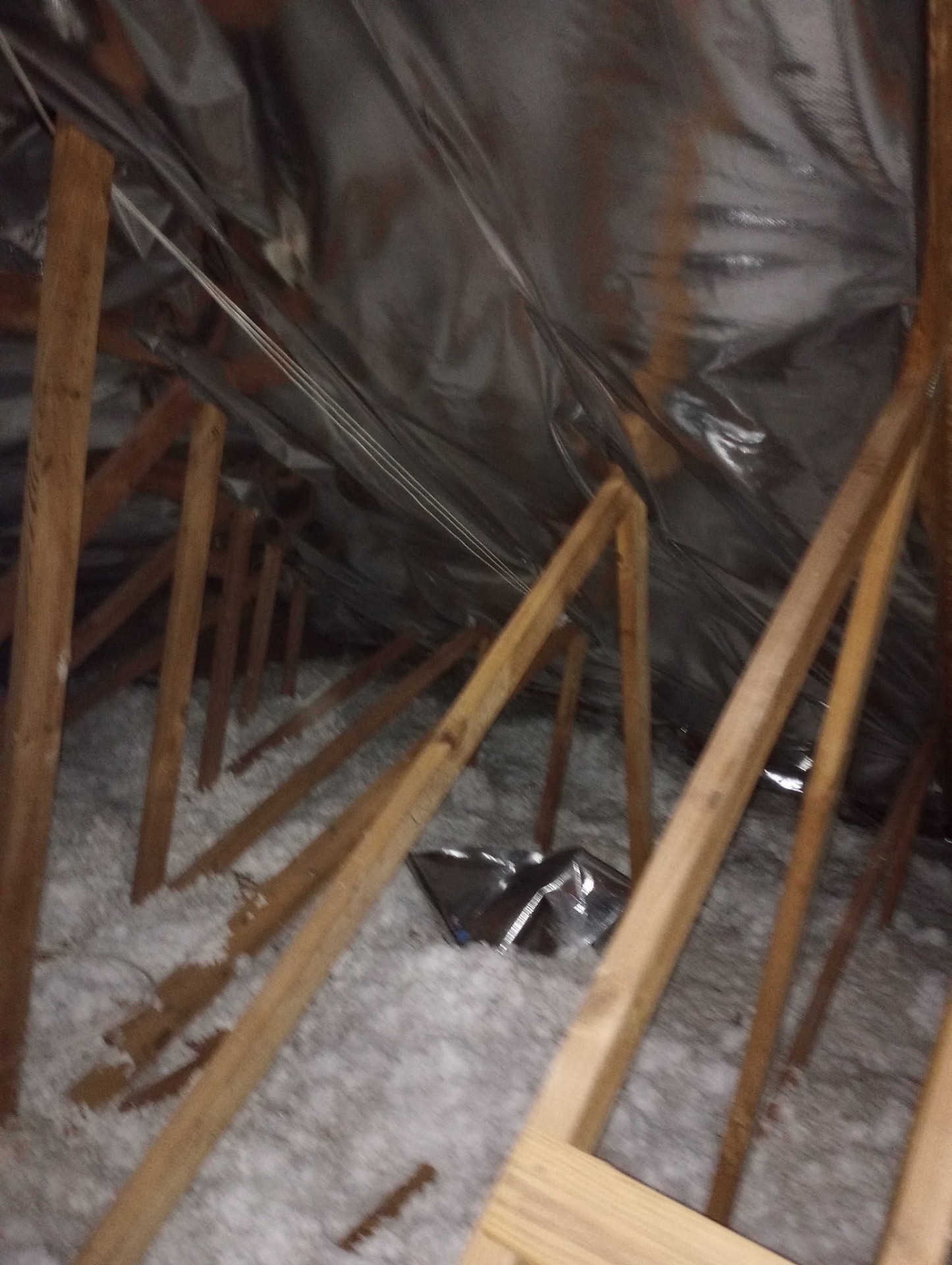Radiant barrier and blown-in insulation installed across attic rafters and floor in a Florida home