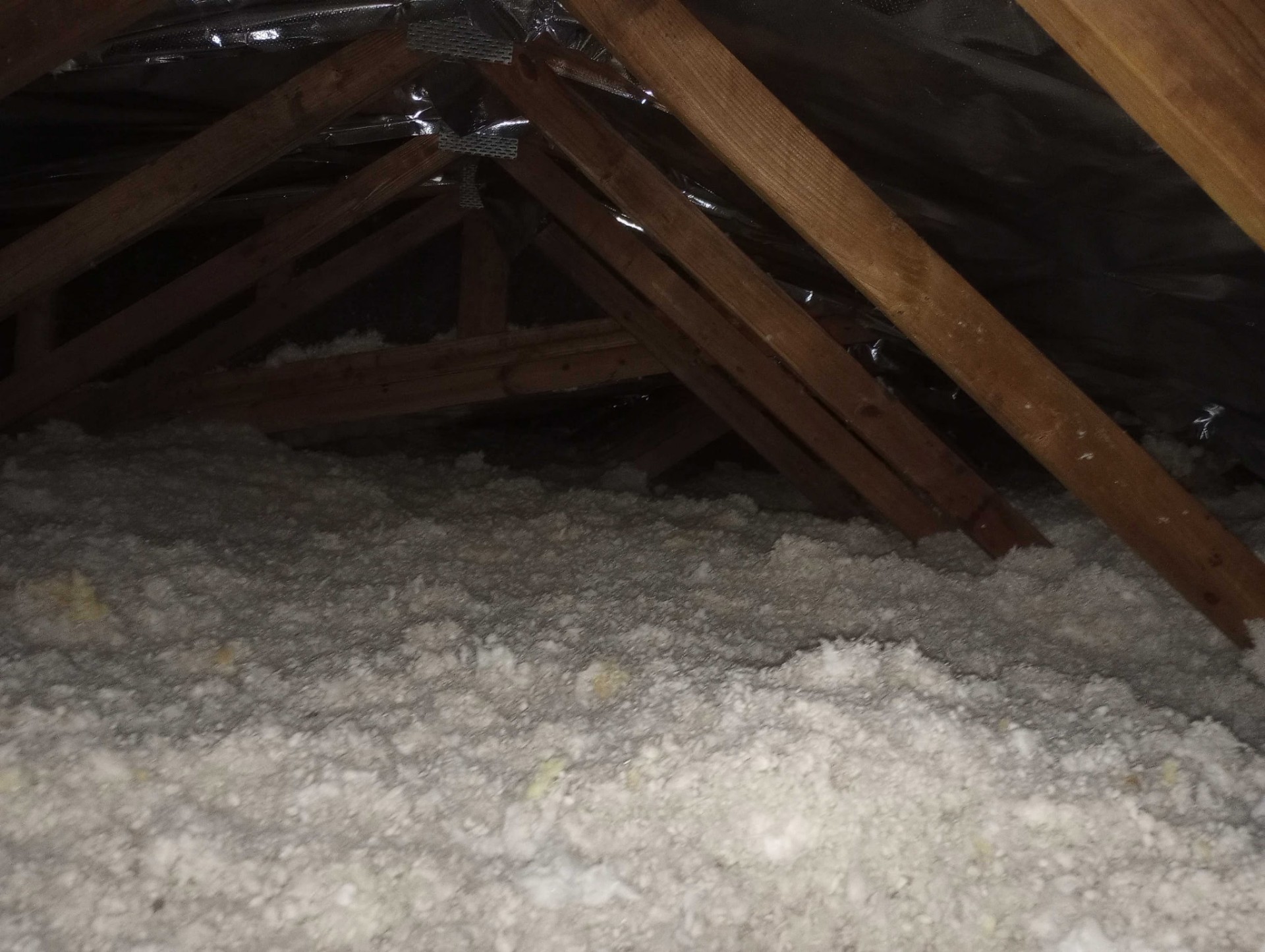 Old attic wiring and debris exposed before insulation removal in Deltona FL home